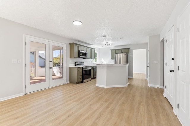 632 Tall Oaks Dr, Gahanna, OH 43230 - kitchen featuring light countertops, a textured ceiling, appliances with stainless steel finishes, and light wood-style flooring