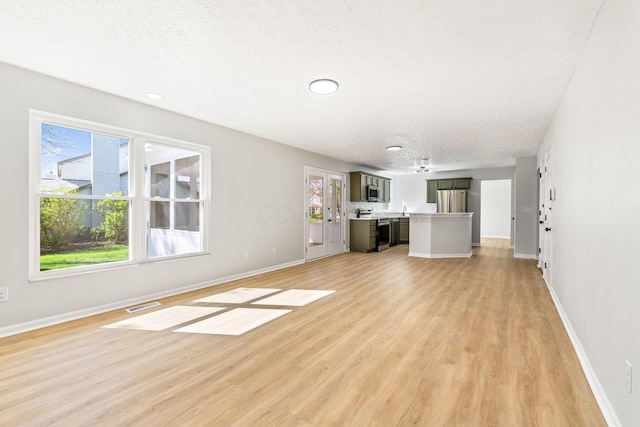 632 Tall Oaks Dr, Gahanna, OH 43230 - unfurnished living room with visible vents, a textured ceiling, baseboards, and light wood-type flooring