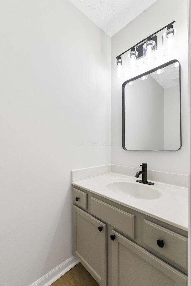 632 Tall Oaks Dr, Gahanna, OH 43230 - bathroom featuring vanity, baseboards, a textured ceiling, and wood finished floors