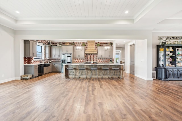 kitchen with a kitchen bar, dishwasher, gray cabinetry, custom exhaust hood, and light wood-style flooring