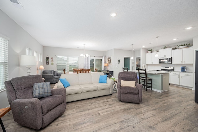 458 Madison Way, Plain City, OH 43064 - living area featuring recessed lighting, light wood-type flooring, a textured ceiling, visible vents, and a notable chandelier