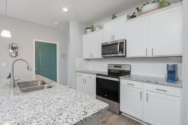 458 Madison Way, Plain City, OH 43064 - kitchen with a sink, appliances with stainless steel finishes, light wood-type flooring, white cabinets, and decorative backsplash