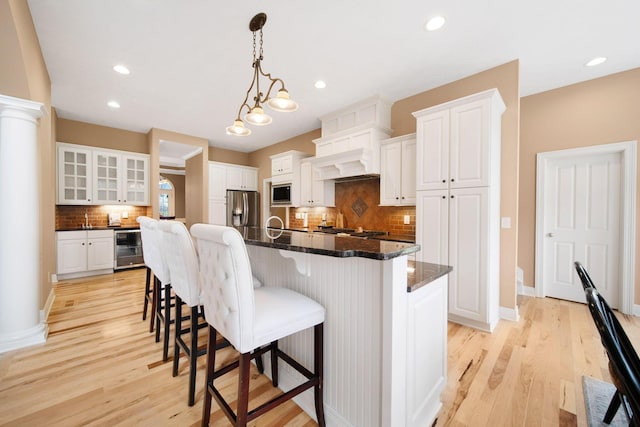 kitchen with stainless steel fridge, light wood-style floors, backsplash, beverage cooler, and built in microwave