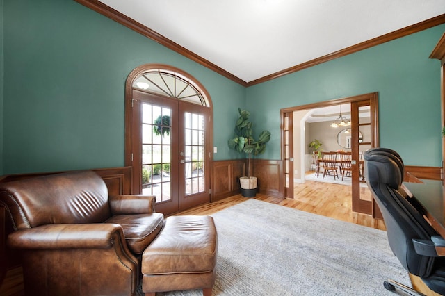 office space with crown molding, wainscoting, wood finished floors, vaulted ceiling, and french doors