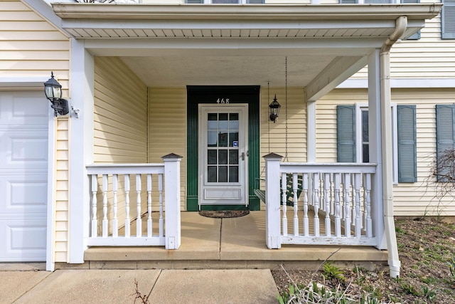entrance to property featuring a garage and a porch