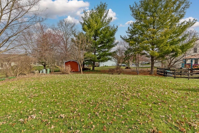 view of yard with a shed, an outbuilding, and fence