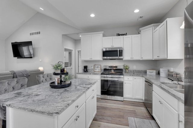 13334 Pine Rd NE, Thornville, OH 43076 - kitchen with appliances with stainless steel finishes, light wood-type flooring, white cabinetry, a kitchen island, and lofted ceiling