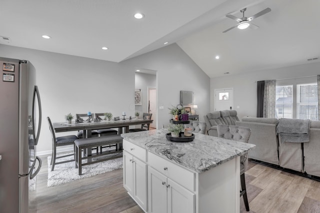 13334 Pine Rd NE, Thornville, OH 43076 - kitchen with freestanding refrigerator, open floor plan, white cabinets, a center island, and light wood-type flooring