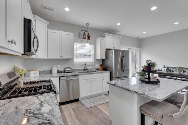 13334 Pine Rd NE, Thornville, OH 43076 - kitchen with stainless steel appliances, light wood finished floors, white cabinets, recessed lighting, and a kitchen island