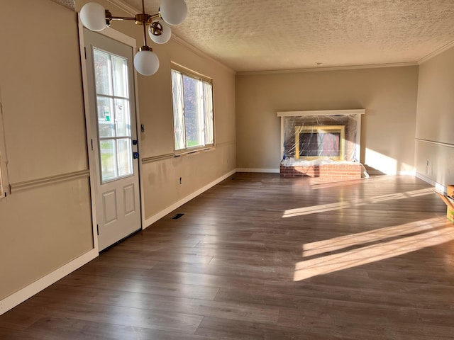 unfurnished living room featuring baseboards, ornamental molding, a textured ceiling, and a brick fireplace