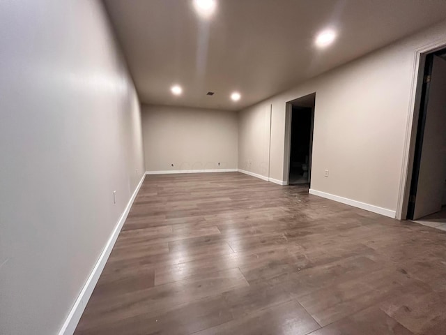 spare room featuring baseboards, recessed lighting, and wood finished floors