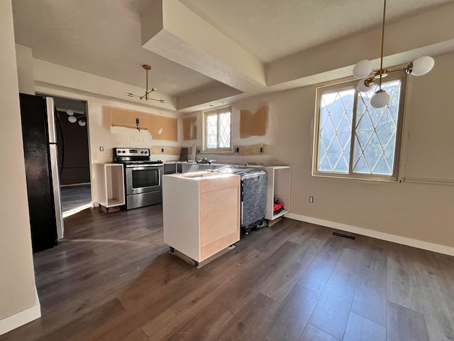 kitchen with appliances with stainless steel finishes, baseboards, visible vents, a peninsula, and dark wood-style floors