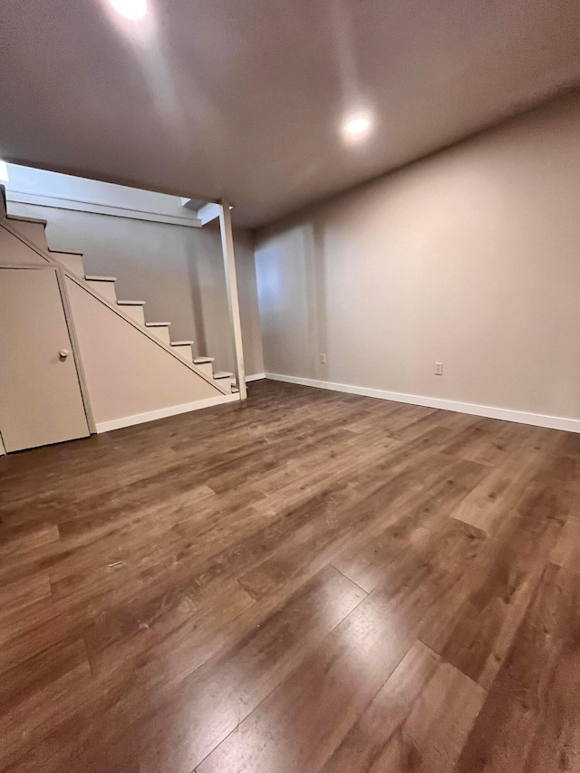finished basement featuring baseboards, stairway, and wood finished floors