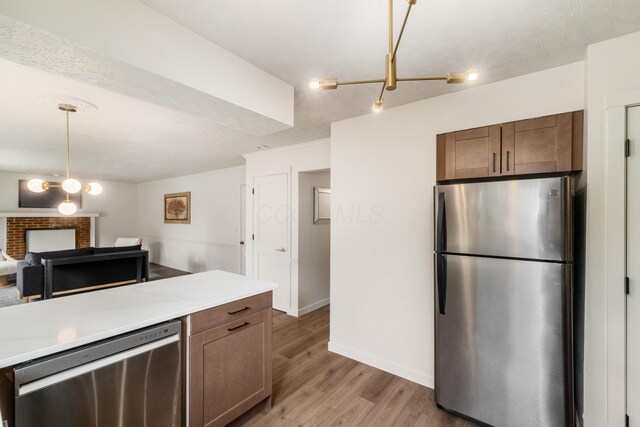 11795 Huntington Way NW, Pickerington, OH 43147 - kitchen featuring appliances with stainless steel finishes, light wood-style floors, light countertops, and pendant lighting