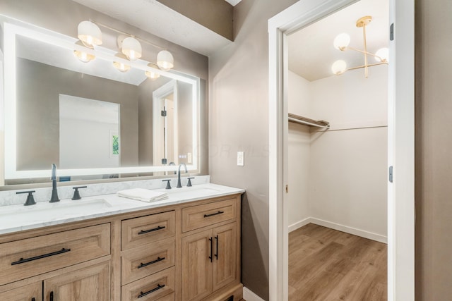 11795 Huntington Way NW, Pickerington, OH 43147 - bathroom featuring double vanity, wood finished floors, a spacious closet, and a chandelier