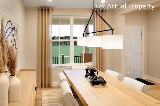 dining space with baseboards and wood finished floors