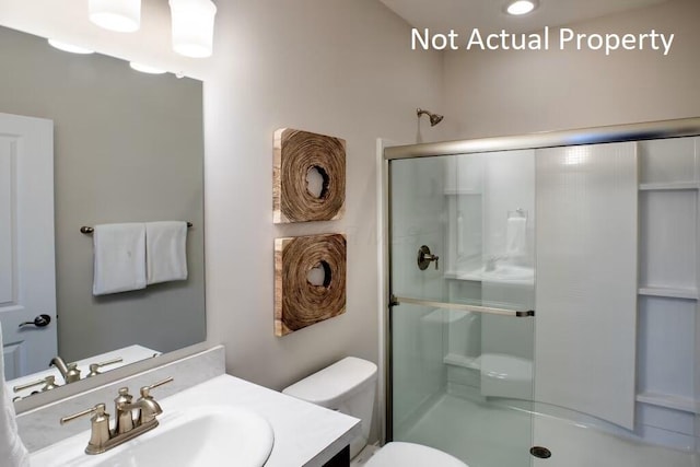full bathroom featuring toilet, vanity, and a stall shower