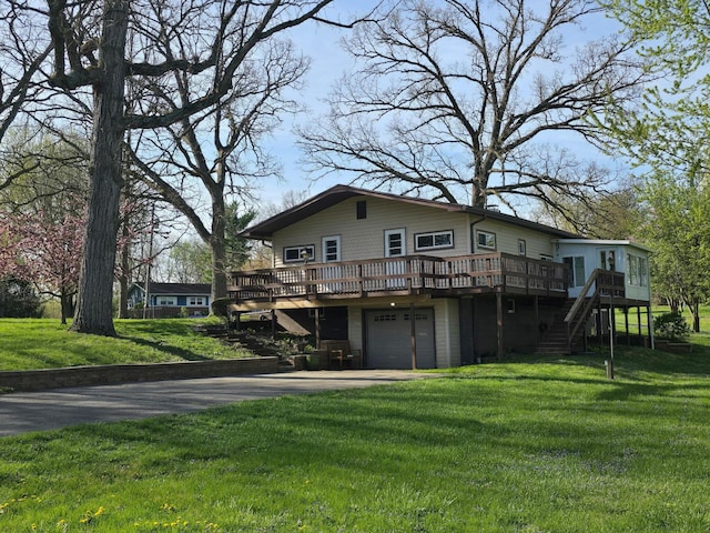 rear view of property featuring an attached garage, driveway, stairway, and a deck