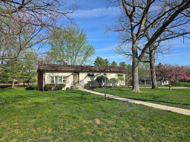 ranch-style home with a front lawn, entry steps, and a chimney