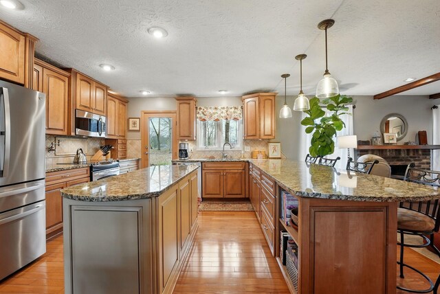 397 E Schrock Rd, Westerville, OH 43081 - kitchen with a kitchen bar, stainless steel appliances, a sink, light wood-style floors, and a peninsula
