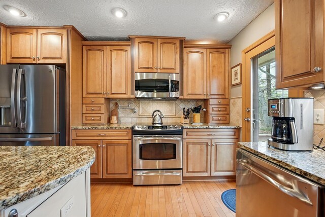 397 E Schrock Rd, Westerville, OH 43081 - kitchen featuring light stone countertops, light wood finished floors, and appliances with stainless steel finishes