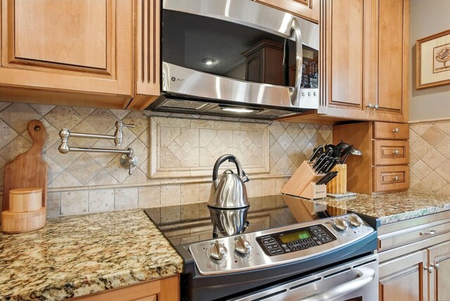 397 E Schrock Rd, Westerville, OH 43081 - kitchen featuring light stone countertops, stainless steel appliances, tasteful backsplash, and brown cabinets