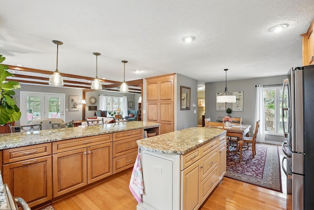 397 E Schrock Rd, Westerville, OH 43081 - kitchen featuring freestanding refrigerator, a center island, light stone counters, and light wood-type flooring