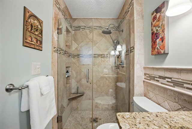 397 E Schrock Rd, Westerville, OH 43081 - bathroom with toilet, a textured ceiling, tile walls, and a shower stall