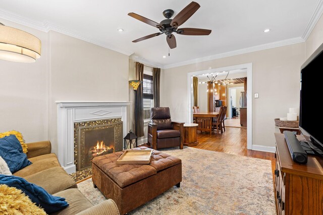 living room featuring crown molding, wood finished floors, and a ceiling fan