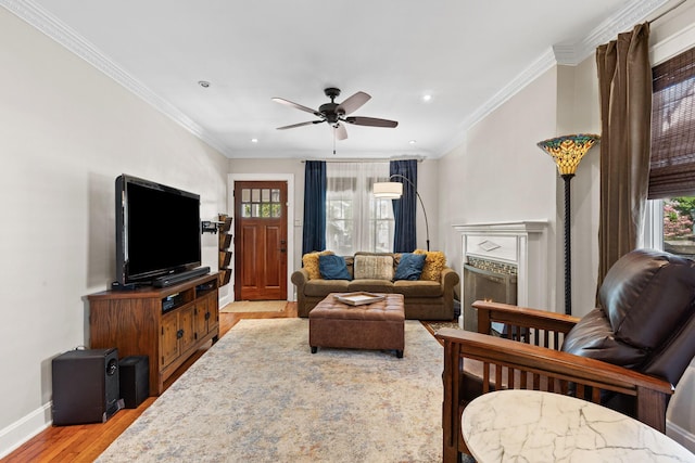 living room with crown molding, light wood-type flooring, and a healthy amount of sunlight