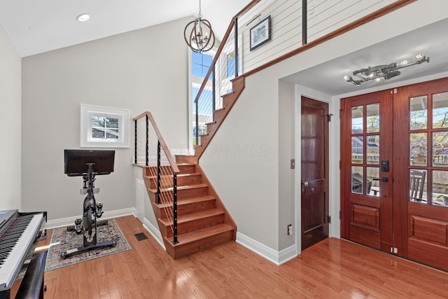 entryway with baseboards, a notable chandelier, stairway, and french doors