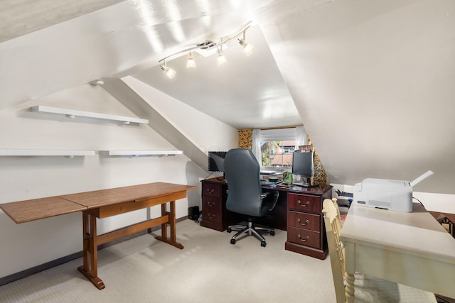 office space with rail lighting, light carpet, lofted ceiling, and baseboards