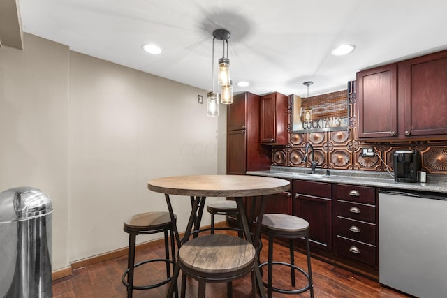 kitchen featuring a sink, stainless steel refrigerator, backsplash, and dark wood-style floors