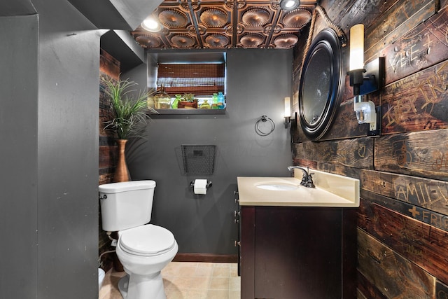 bathroom with toilet, baseboards, and vanity