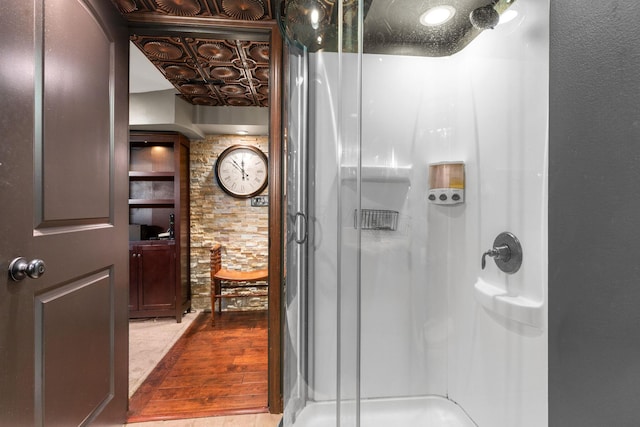 bathroom featuring a shower stall and wood finished floors