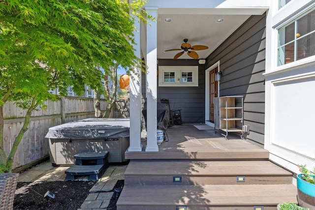 view of patio with a hot tub, fence, a deck, and ceiling fan