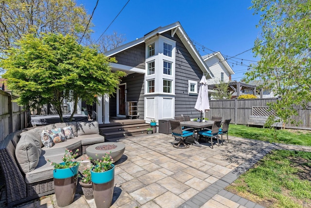 rear view of house with an outdoor living space with a fire pit, a patio, outdoor dining space, and a fenced backyard
