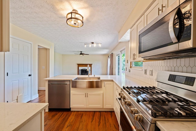 488 Springwood Lake Dr, Columbus, OH 43230 - kitchen with stainless steel appliances, a peninsula, dark wood finished floors, a sink, and a textured ceiling