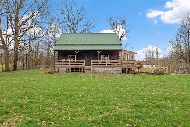 view of front of property with a front lawn, metal roof, a deck, and log exterior