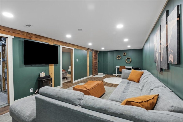 living area featuring baseboards, wood finished floors, and recessed lighting