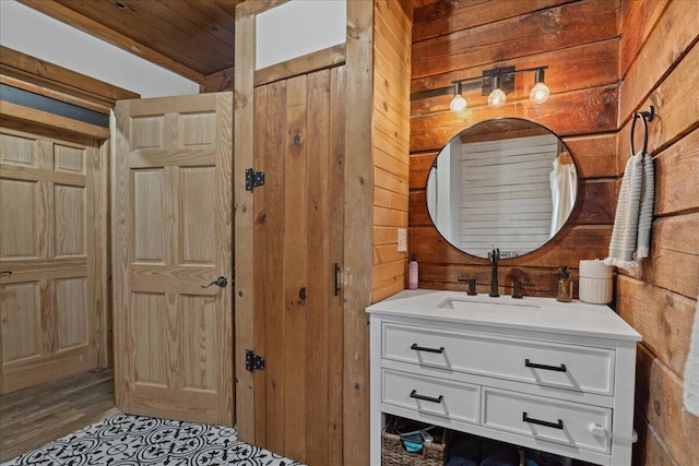 bathroom featuring vanity, wooden walls, and wood finished floors