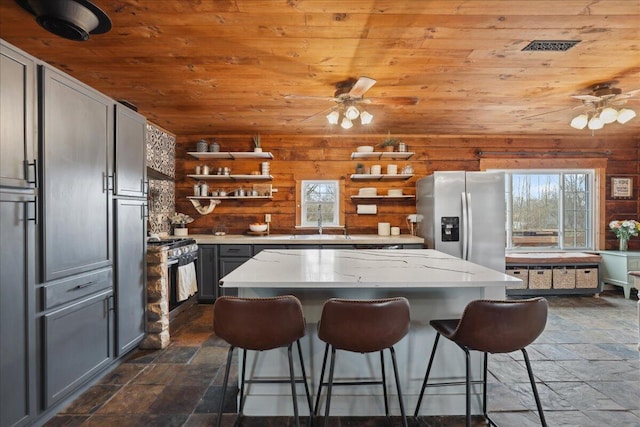 kitchen with wooden ceiling, appliances with stainless steel finishes, open shelves, and ceiling fan