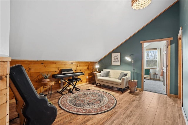 sitting room with lofted ceiling, wood finished floors, and wood walls