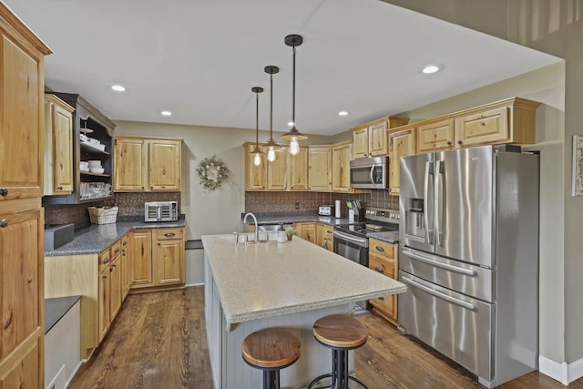 18738 State Route 327, Laurelville, OH 43135 - kitchen with tasteful backsplash, dark wood finished floors, light stone counters, an island with sink, and appliances with stainless steel finishes