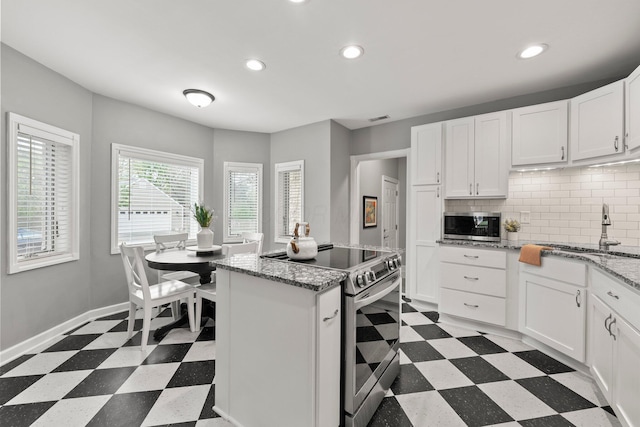 kitchen with recessed lighting, a sink, light floors, and stainless steel appliances