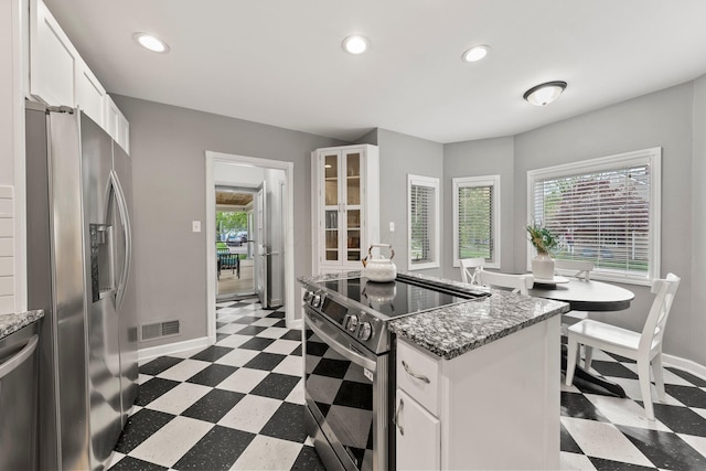 kitchen with dark floors, appliances with stainless steel finishes, baseboards, and visible vents