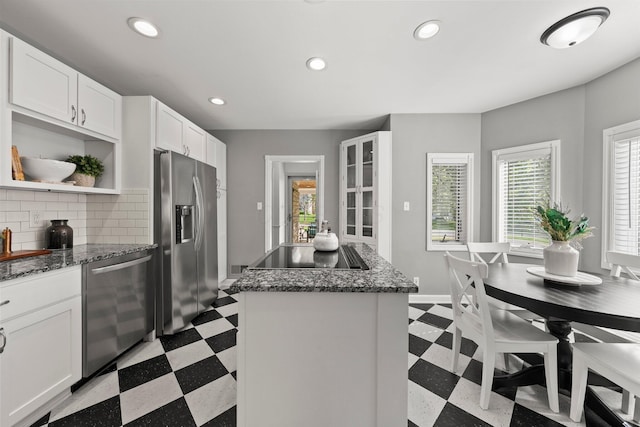 kitchen with a center island, open shelves, light floors, and appliances with stainless steel finishes