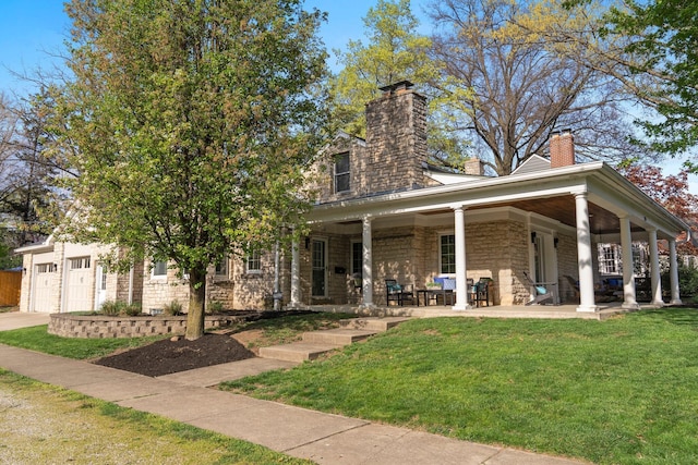 view of front facade featuring a chimney, an attached garage, driveway, and a front yard