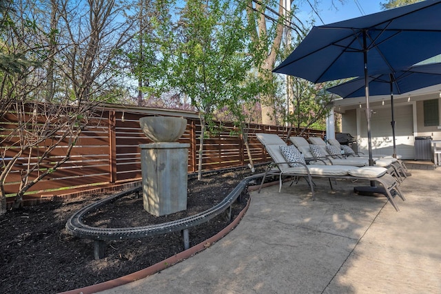 view of patio featuring area for grilling and fence