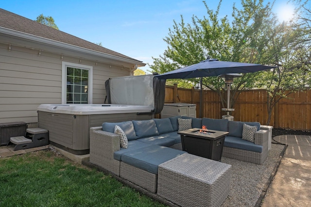 view of patio / terrace with a fenced backyard, an outdoor living space with a fire pit, and a hot tub